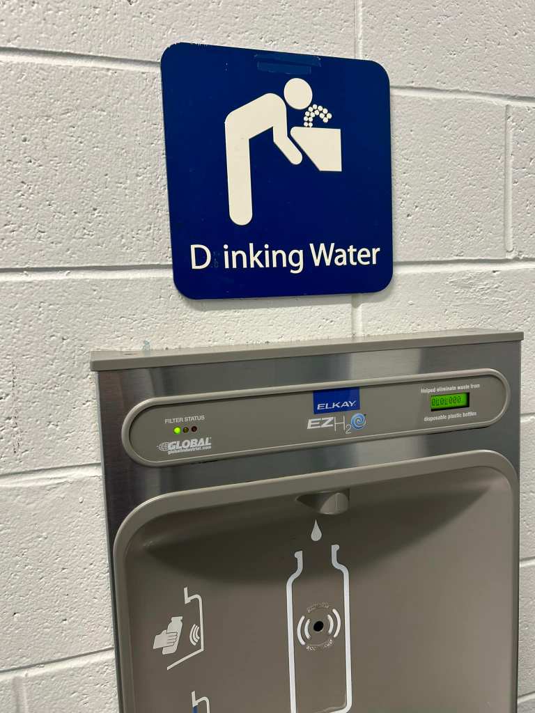 water fountain with sign that said "drinking water," but someone vandalized it so it says Dinking water