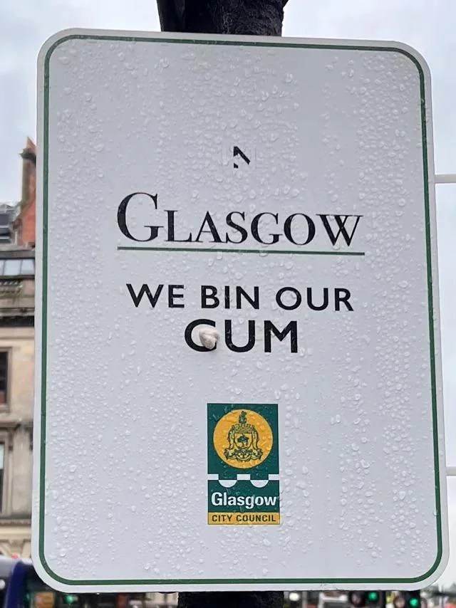 sign that says "in Glasgow we bin our gum," but someone put gum over the word gum so it looks like "cum."